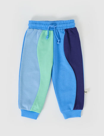 The Goldie + Ace Rio Wave Terry Sweatpants Ocean Blue in Blue pictured on a grey background. The material is 100% cotton french terry. It is a bottom made for babies, toddlers and kids.