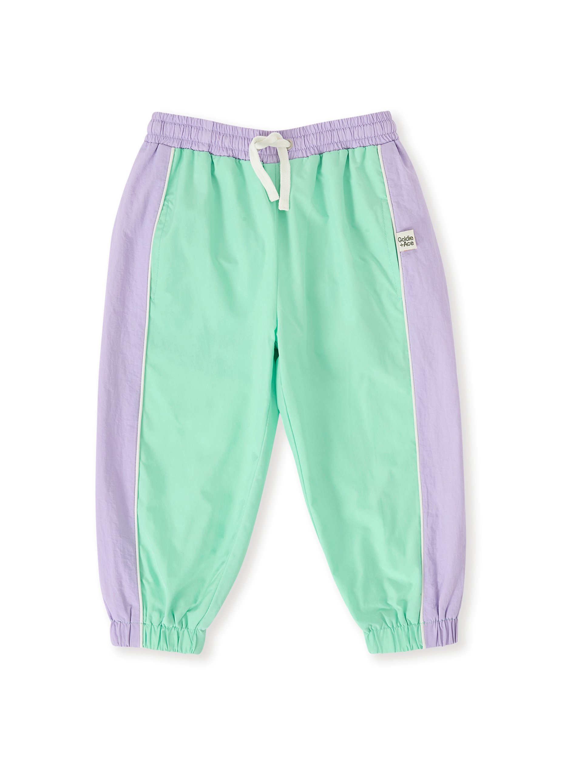 The Goldie + Ace Retro Sporty Pants in Peapod/Lilac pictured on a transparent background. The material is poly with cotton lining. It is a bottom made for babies, toddlers and kids.