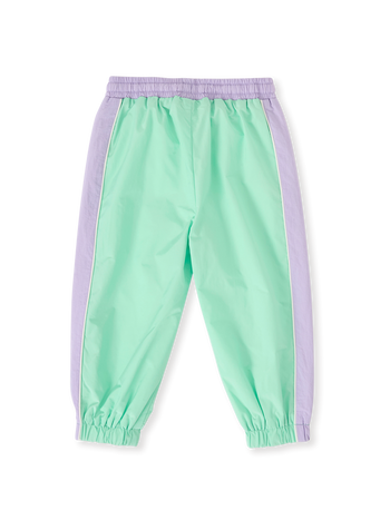 The Goldie + Ace Retro Sporty Pants in Peapod/Lilac pictured on a transparent background. The material is poly with cotton lining. It is a bottom made for babies, toddlers and kids.