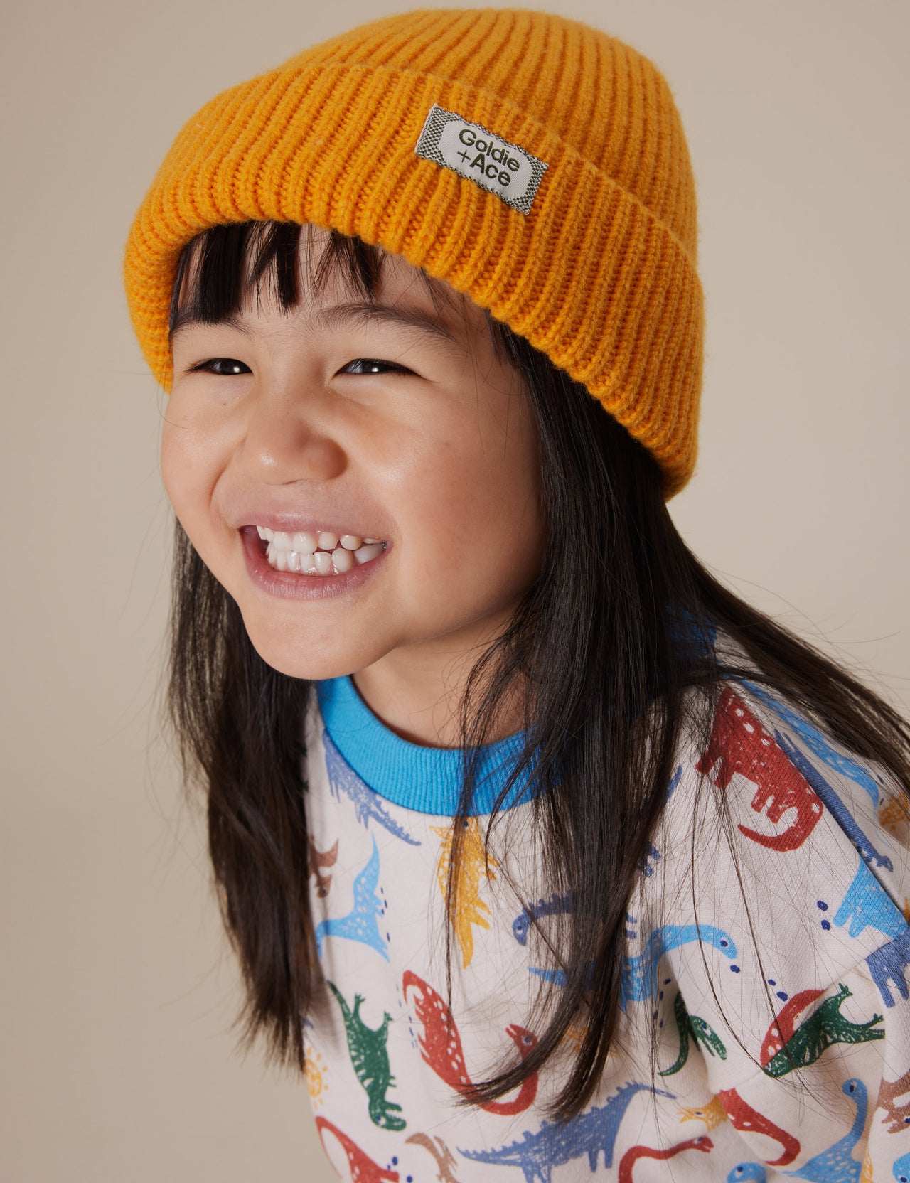 The Goldie + Ace Wool Beanie in Golden pictured on a grey background. The material is 100% merino wool. It is a accessory made for babies, toddlers and kids.