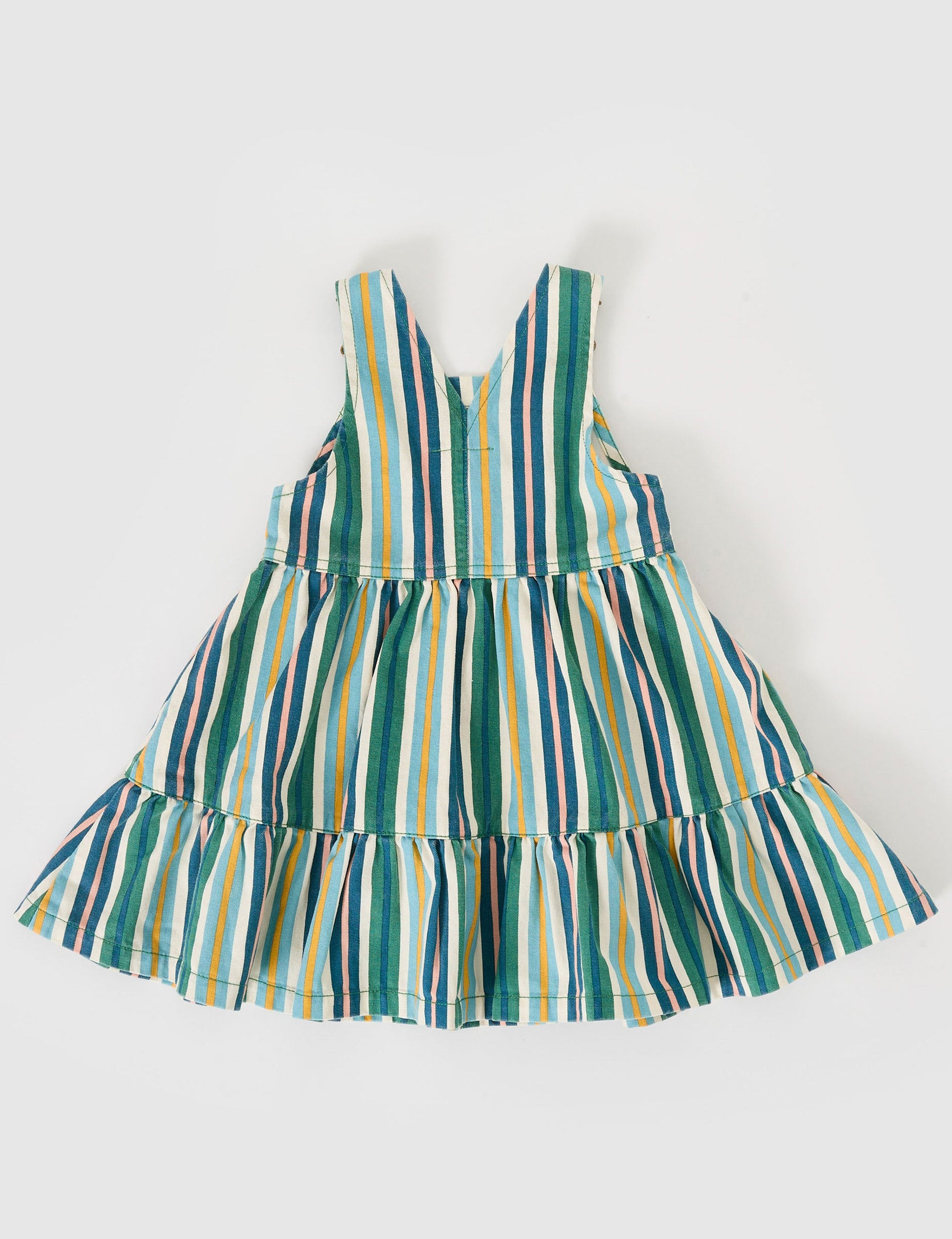 The Goldie + Ace Tully Tiered Pinafore Dress in Evergreen Stripe pictured on a grey background. The material is cotton twill. It is a dress made for babies, toddlers and kids.