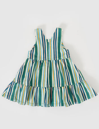 The Goldie + Ace Tully Tiered Pinafore Dress in Evergreen Stripe pictured on a grey background. The material is cotton twill. It is a dress made for babies, toddlers and kids.