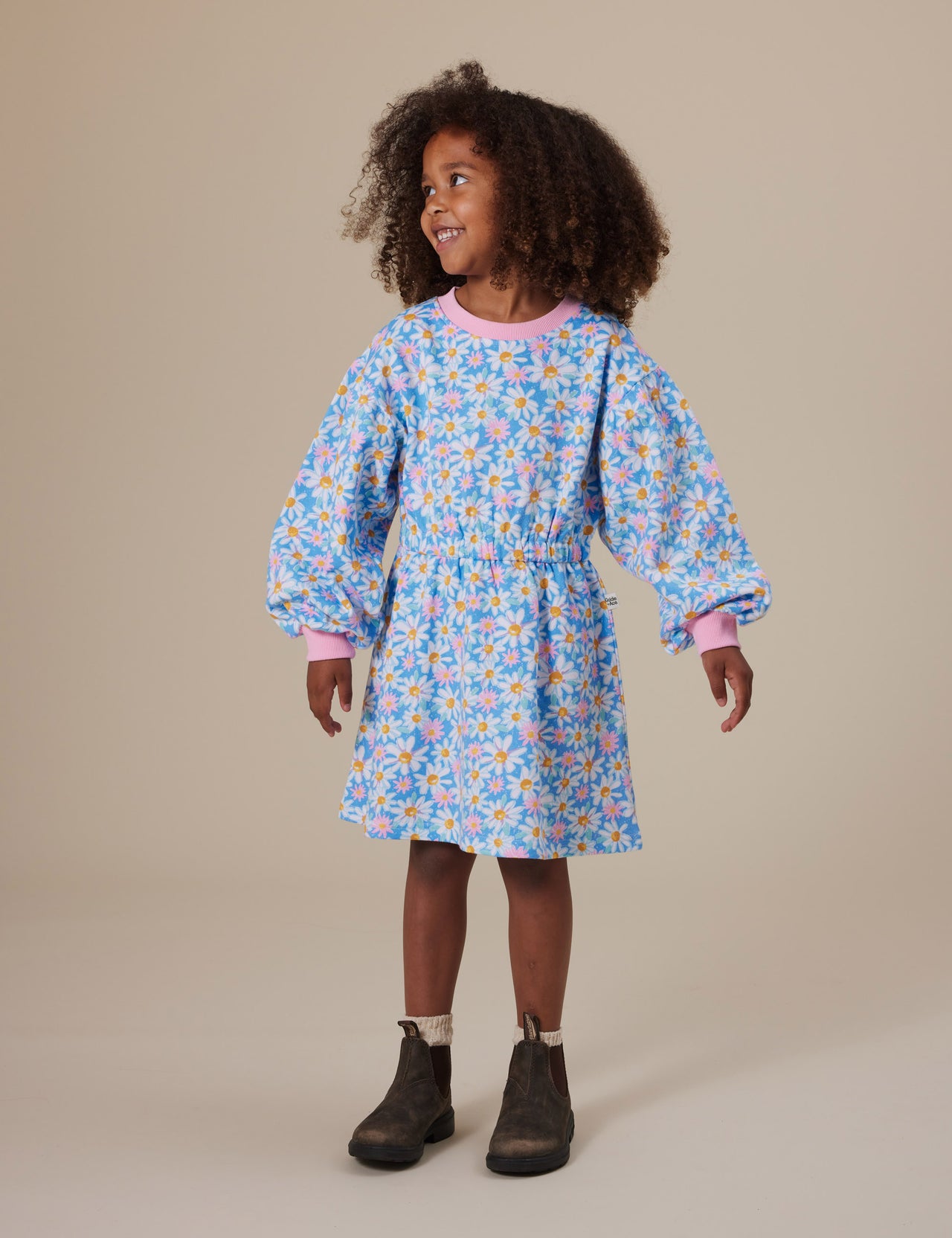 The Goldie + Ace Leah Long Sleeve Dress in Seaside Daisy pictured on a grey background. The material is cotton terry. It is a dress made for babies, toddlers and kids.