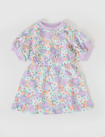 The Goldie + Ace Flora Molly Short Sleeve Dress in Lilac Multi pictured on a grey background. The material is cotton terry. It is a dress made for babies, toddlers and kids.