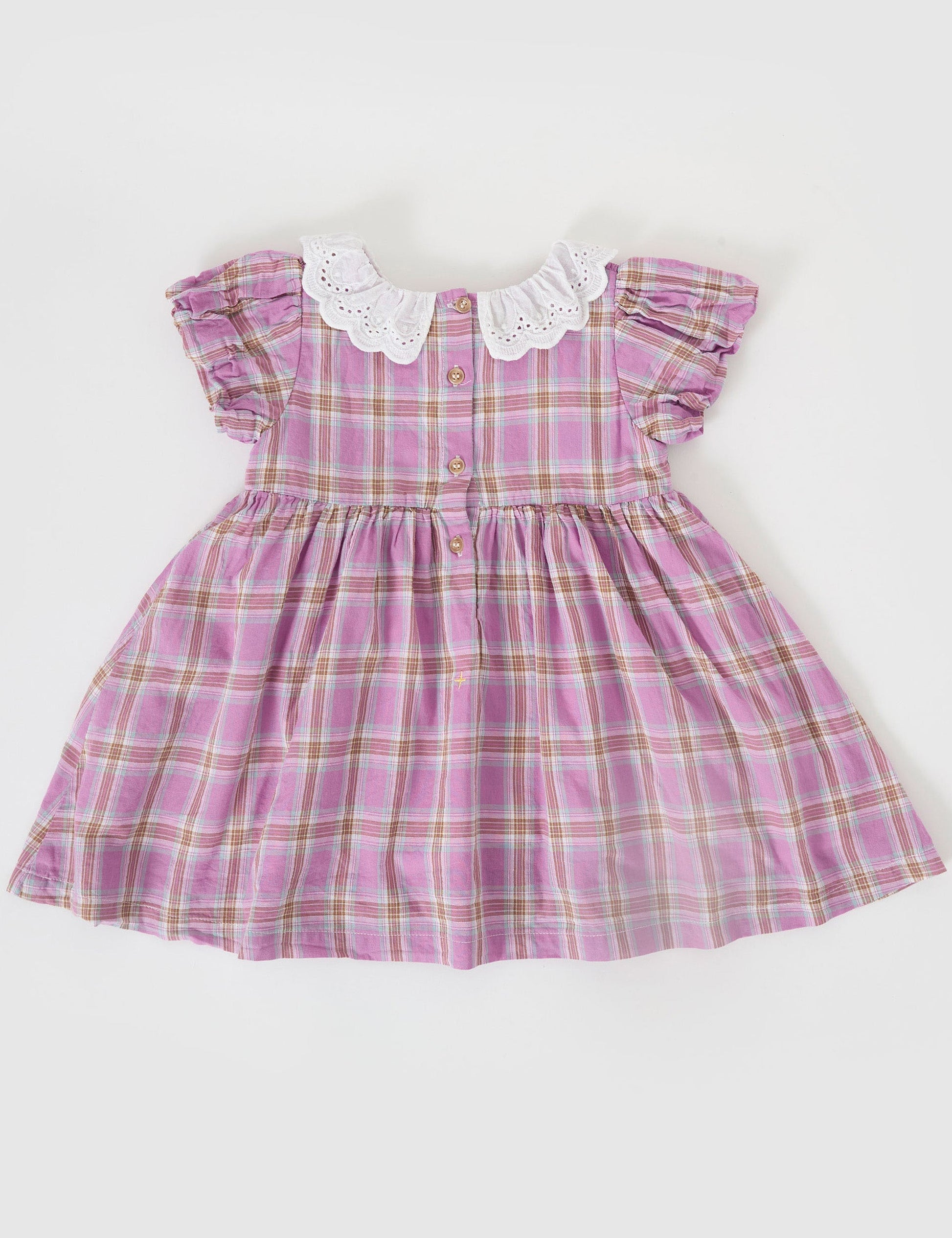 The Goldie + Ace Mauve Check Flo Smocked Dress in Mauve Check pictured on a grey background. The material is cotton. It is a dress made for babies, toddlers and kids.