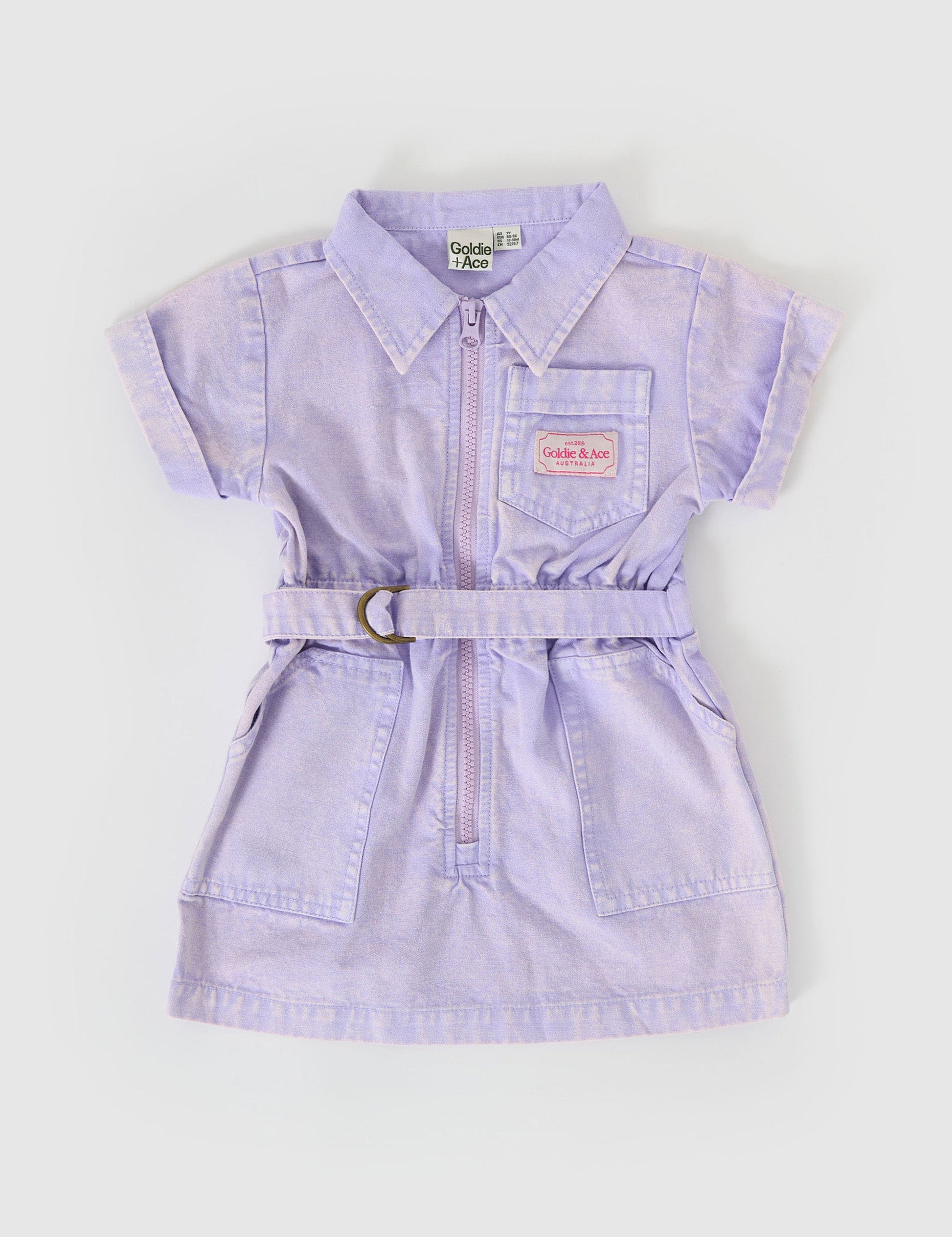 The Goldie + Ace Piper Denim Belted Dress in Mauve pictured on a grey background. The material is cotton twill. It is a dress made for babies, toddlers and kids.