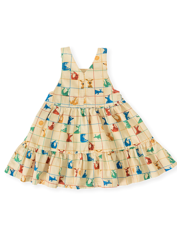 The Goldie + Ace Hopscotch Tully Tiered Pinafore Dress in Vanilla/Primary pictured on a transparent background. The material is 100% cotton. It is a dress made for babies, toddlers and kids.