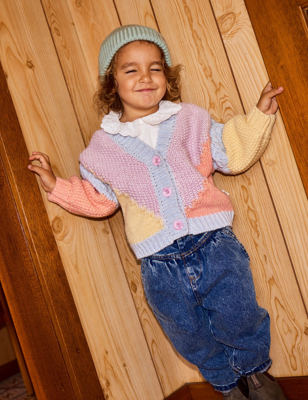 The Goldie + Ace Colour Block Knit Cardigan in Blue/Pink pictured on a grey background. The material is super soft wool blend. It is a knit made for babies, toddlers and kids.