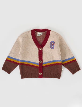 The Goldie + Ace Varsity Knit Cardigan in Vanilla/Brown pictured on a grey background. The material is super soft wool blend. It is a knit made for babies, toddlers and kids.