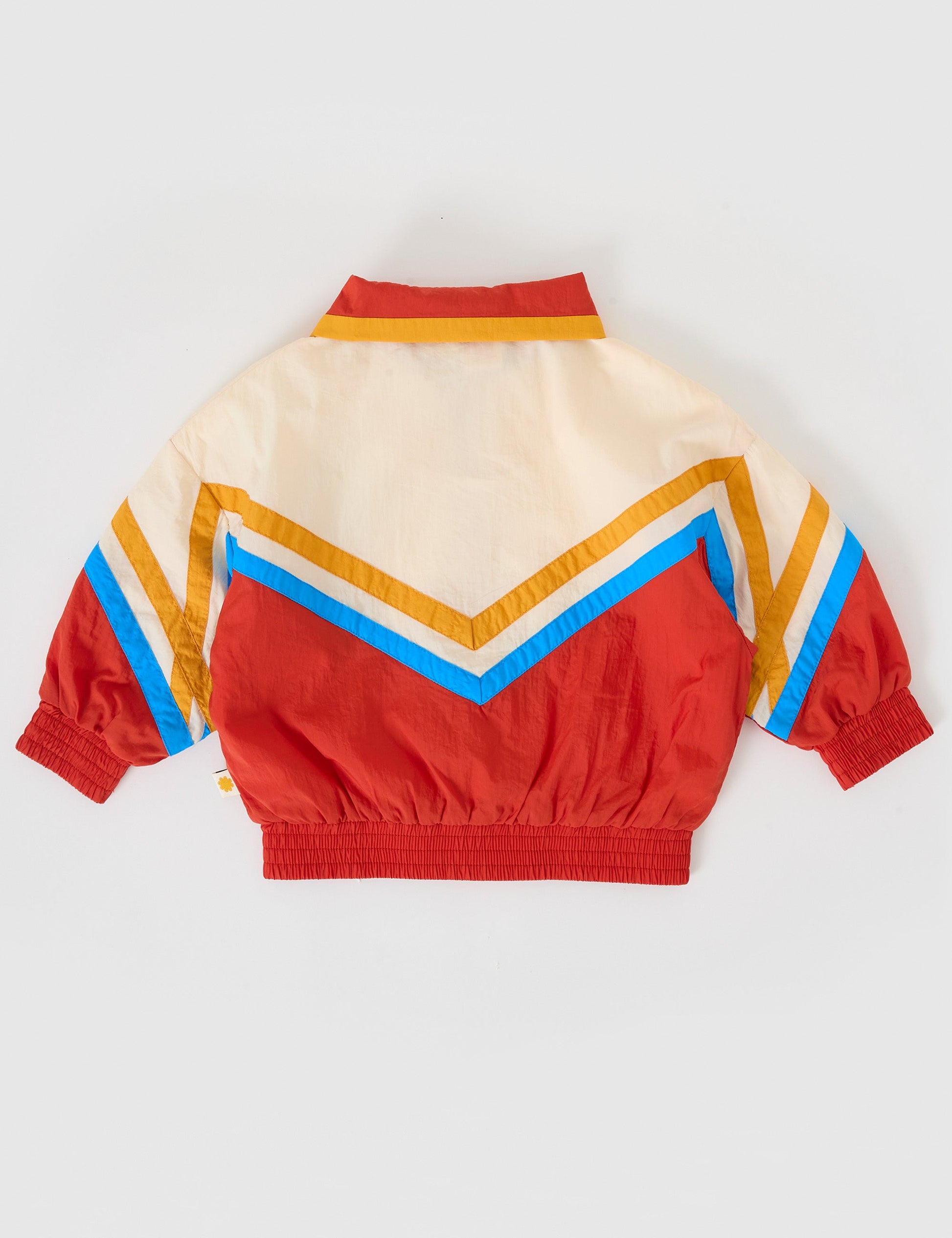 The Goldie + Ace Retro Lightweight Spray Jacket in Red/Vanilla pictured on a grey background. The material is poly with poly lining. It is a jacket made for babies, toddlers and kids.