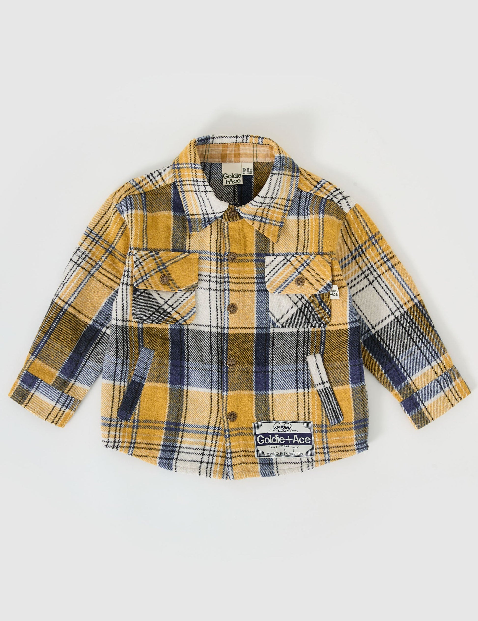 The Goldie + Ace Rowan Check Shirt in Golden pictured on a grey background. The material is poly & cotton with cotton lining. It is a top made for babies, toddlers and kids.