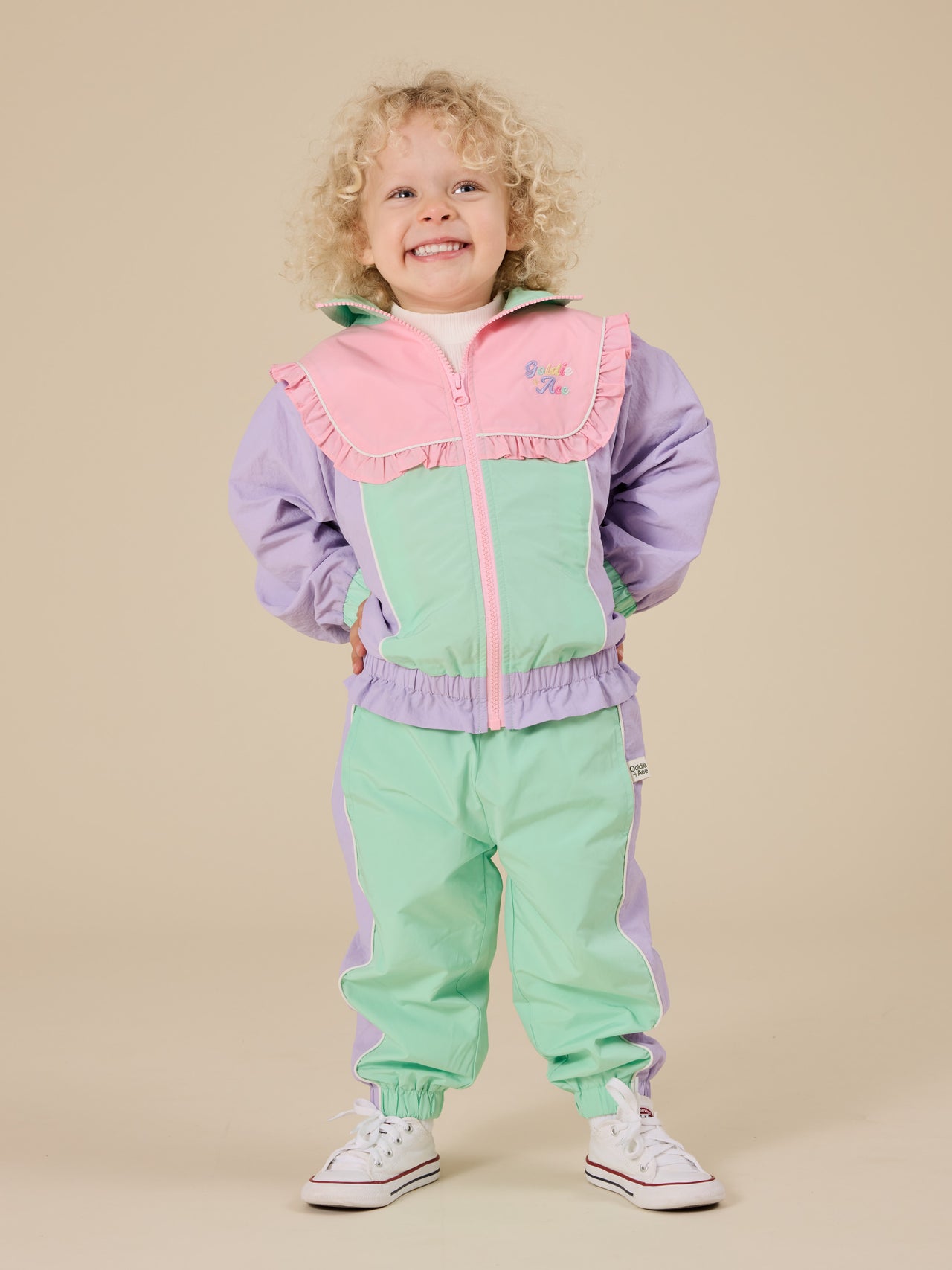 The Goldie + Ace Retro Sporty Pants in Peapod/Lilac pictured on a transparent background. The material is poly with cotton lining. It is a bottom made for babies, toddlers and kids.