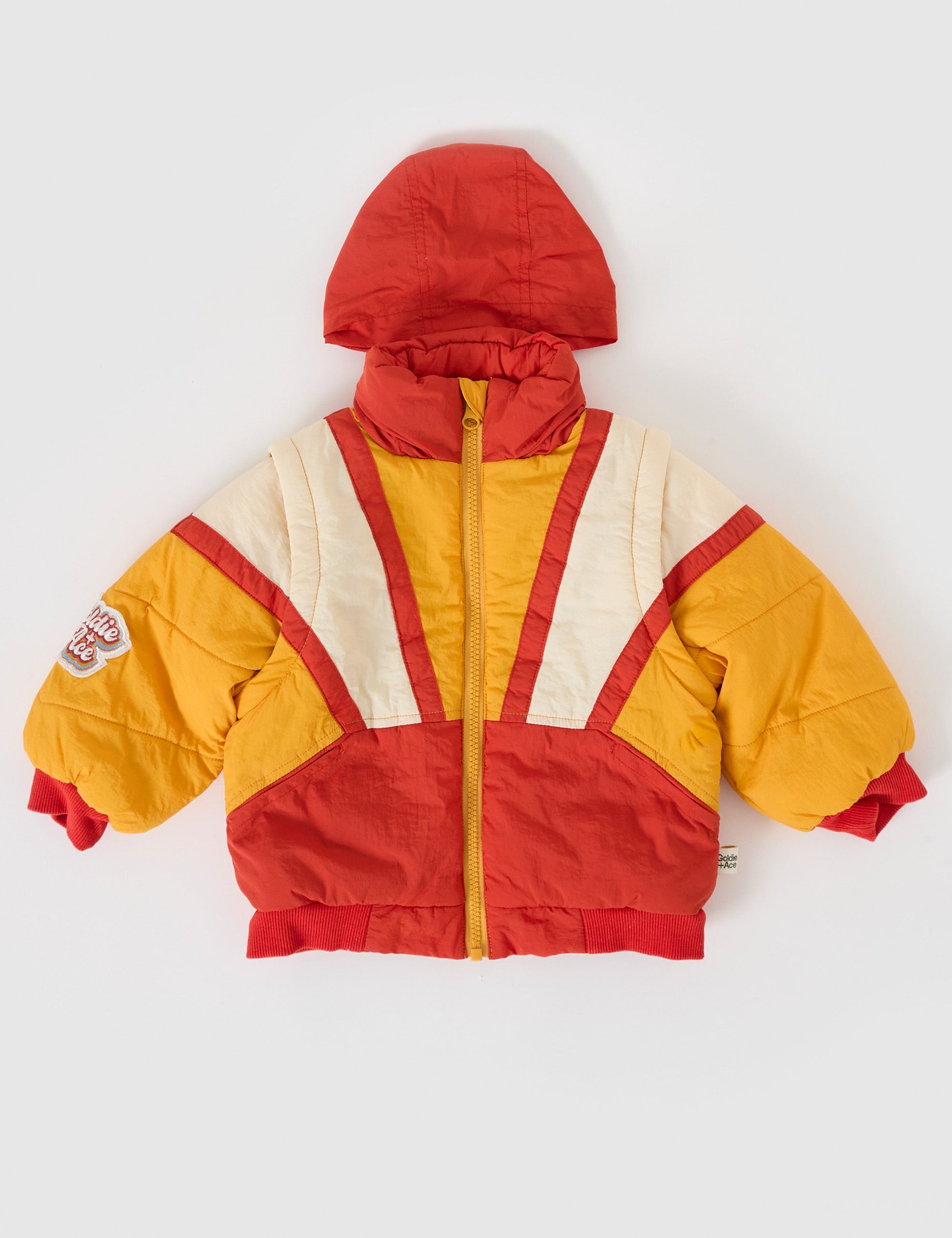 The Goldie + Ace Andy Vest/Jacket in Golden Red pictured on a grey background. The material is poly with poly fill. It is a jacket made for babies, toddlers and kids.