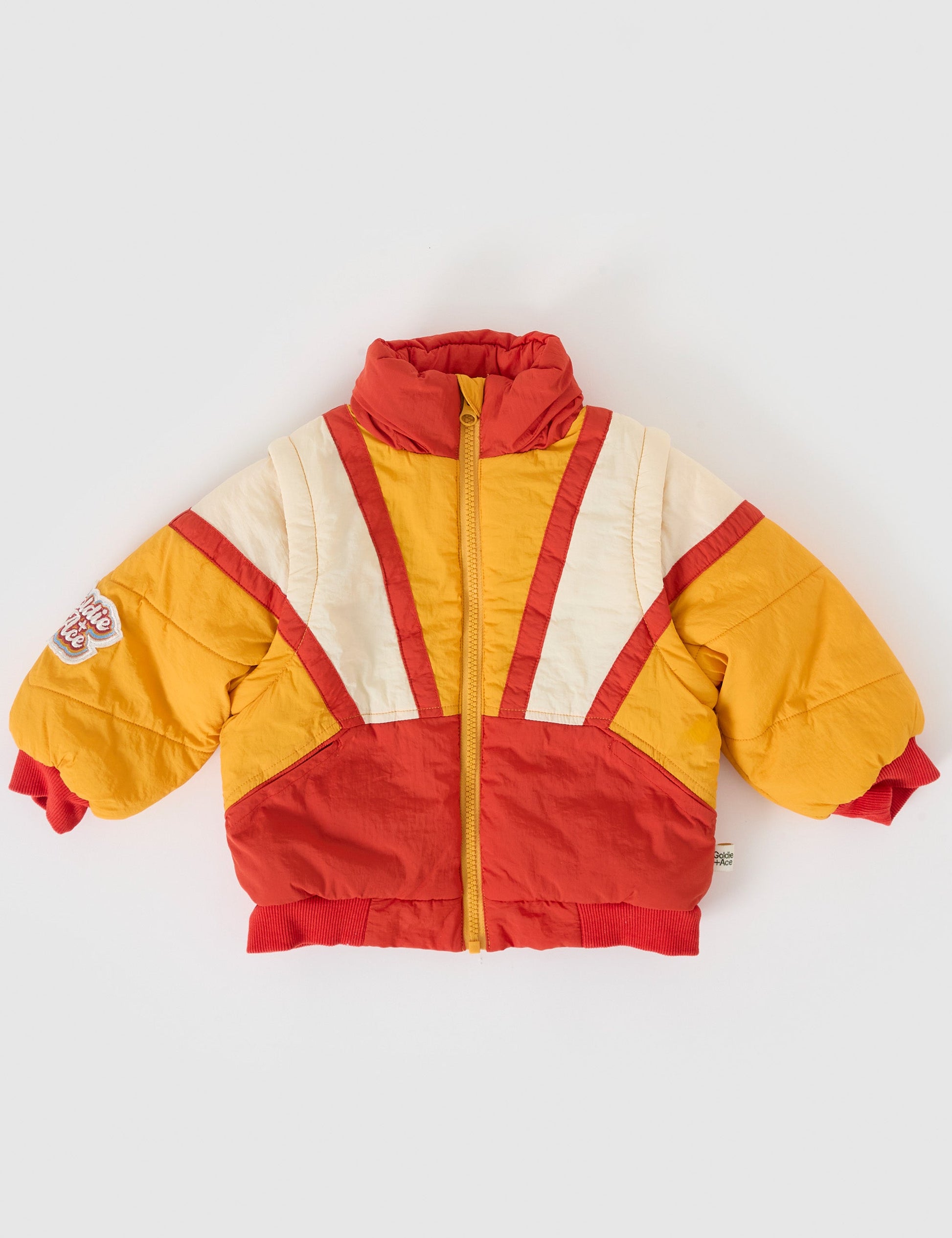 The Goldie + Ace Andy Vest/Jacket in Golden Red pictured on a grey background. The material is poly with poly fill. It is a jacket made for babies, toddlers and kids.