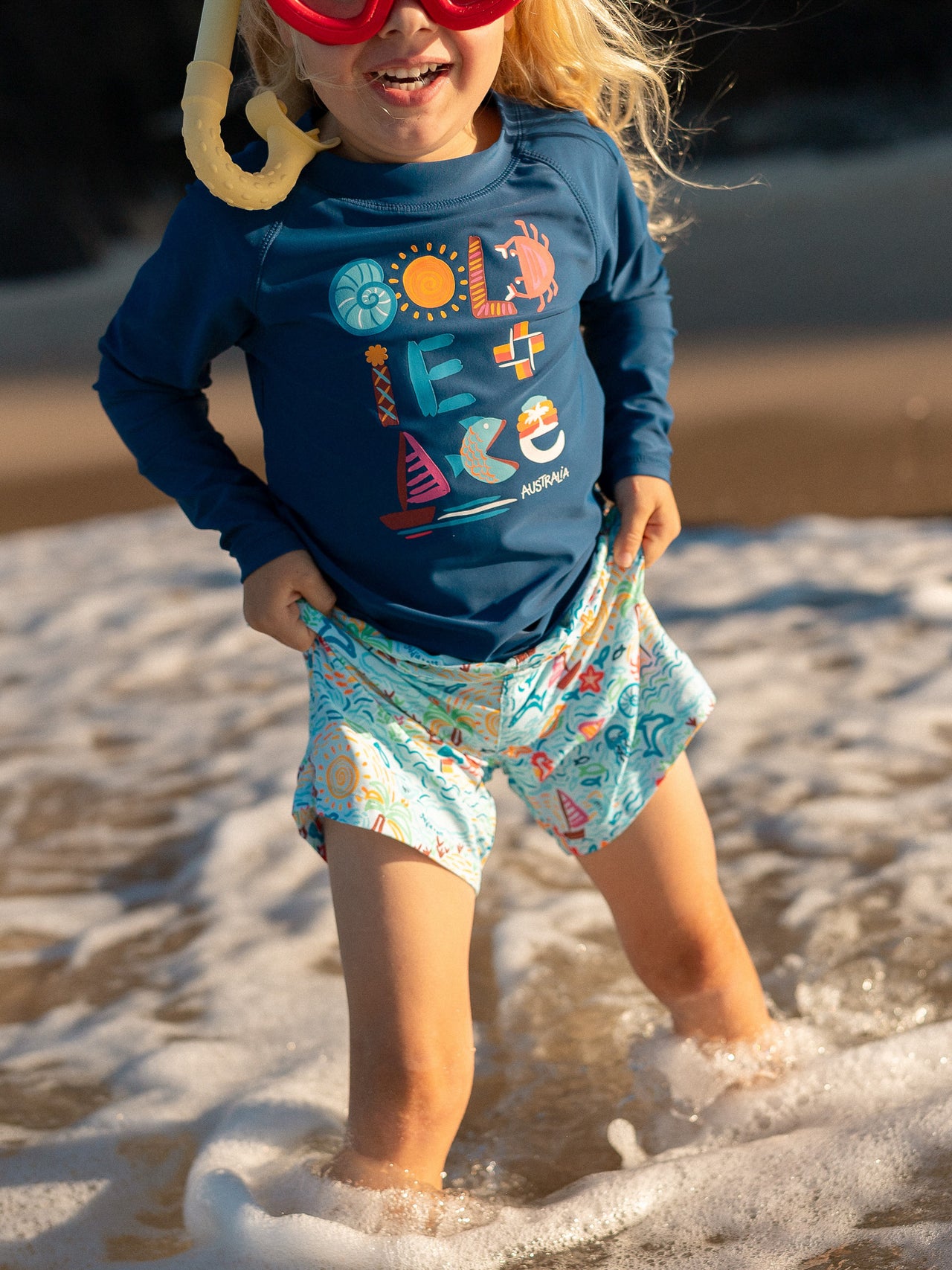 The Goldie + Ace Summer Bay Board Shorts in Multi pictured on a transparent background. The material is . It is a swimwear made for babies, toddlers and kids.
