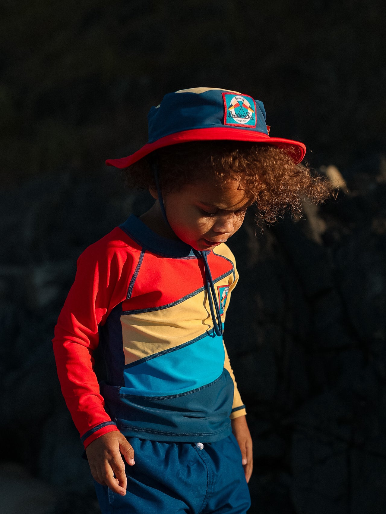 The Goldie + Ace Nautical Flag Swim Bucket Hat in Navy/Red pictured on a transparent background. The material is . It is a swimwear made for babies, toddlers and kids.