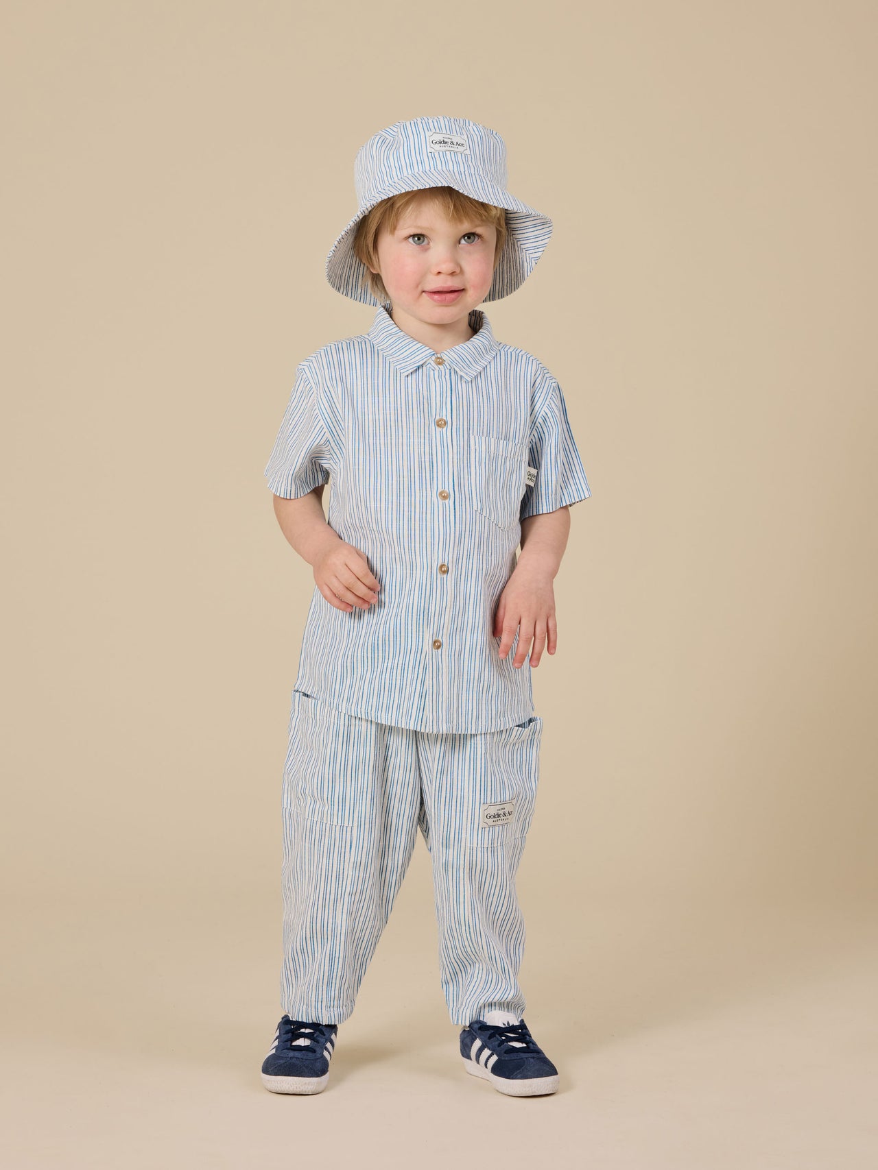 The Goldie + Ace Sailor Stripe Holiday Shirt in Ocean/Ivory pictured on a transparent background. The material is soft and breathable rayon-linen blend. It is a top made for babies, toddlers and kids.