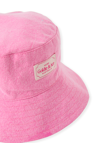 The Goldie + Ace Denim Bucket Hat in Pink Lemonade pictured on a transparent background. The material is cotton with cotton lining. It is a accessory made for babies, toddlers and kids.