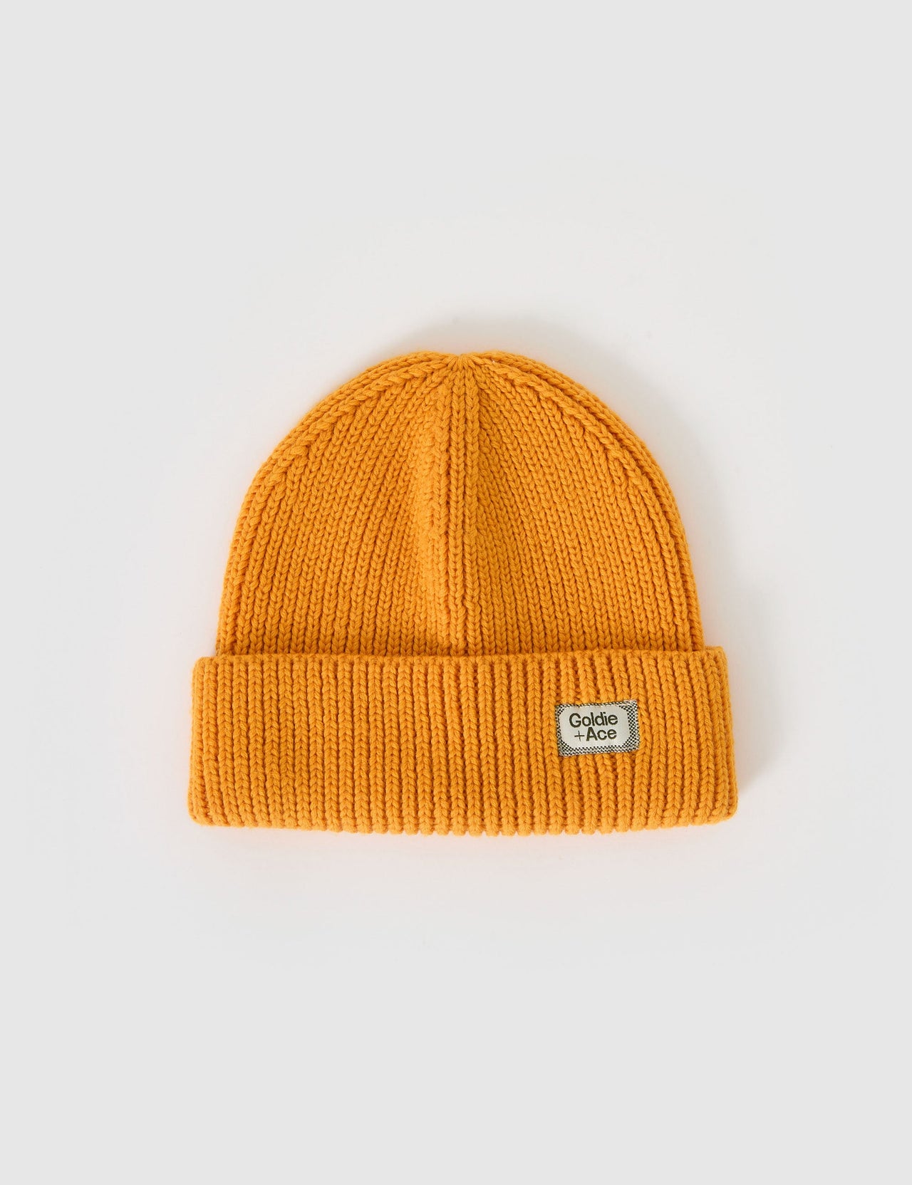 The Goldie + Ace Wool Beanie in Golden pictured on a grey background. The material is 100% merino wool. It is a accessory made for babies, toddlers and kids.