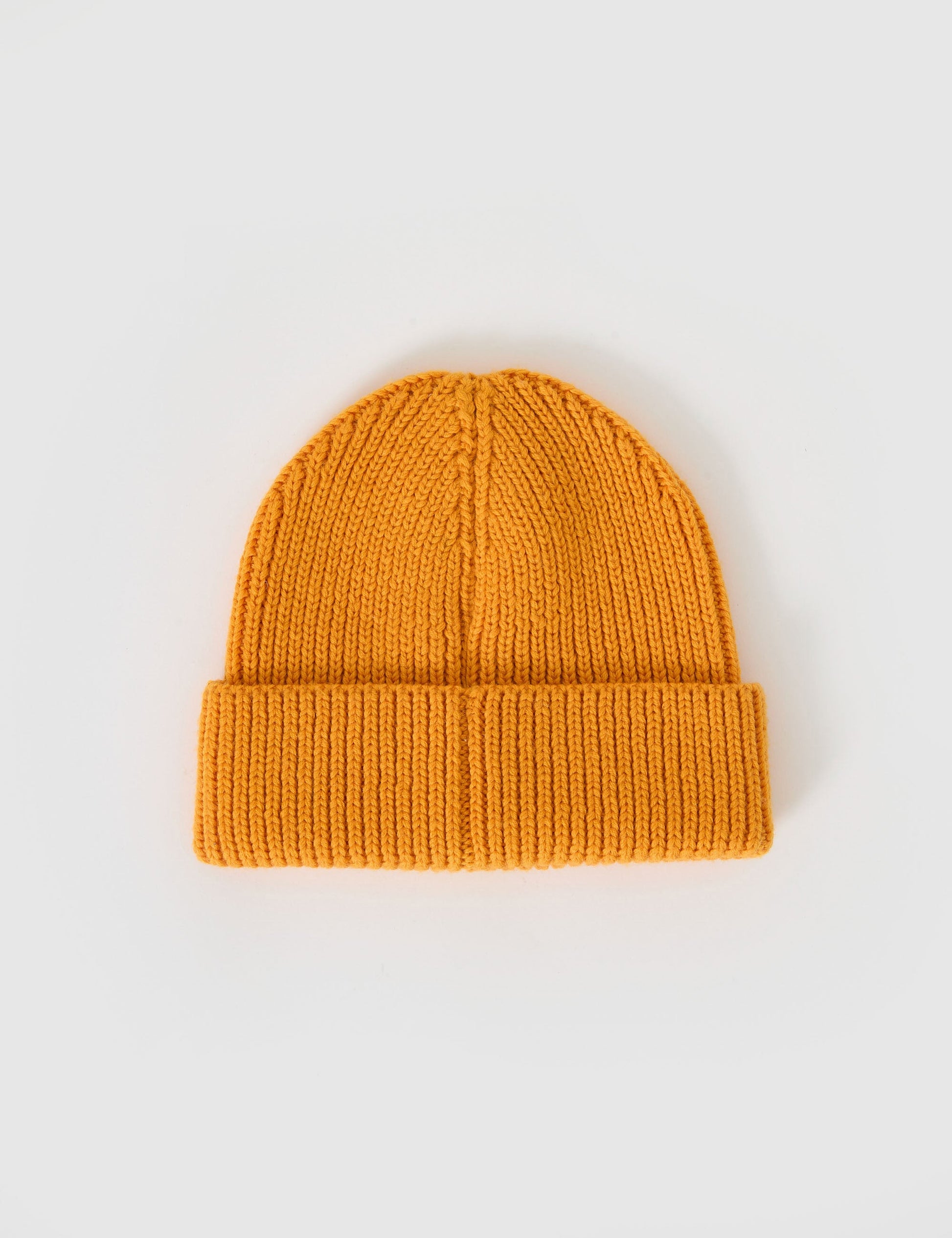 The Goldie + Ace Wool Beanie in Golden pictured on a grey background. The material is 100% merino wool. It is a accessory made for babies, toddlers and kids.