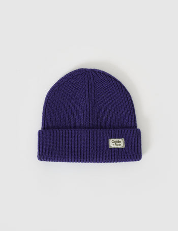 The Goldie + Ace Wool Beanie in Navy pictured on a grey background. The material is 100% merino wool. It is a accessory made for babies, toddlers and kids.