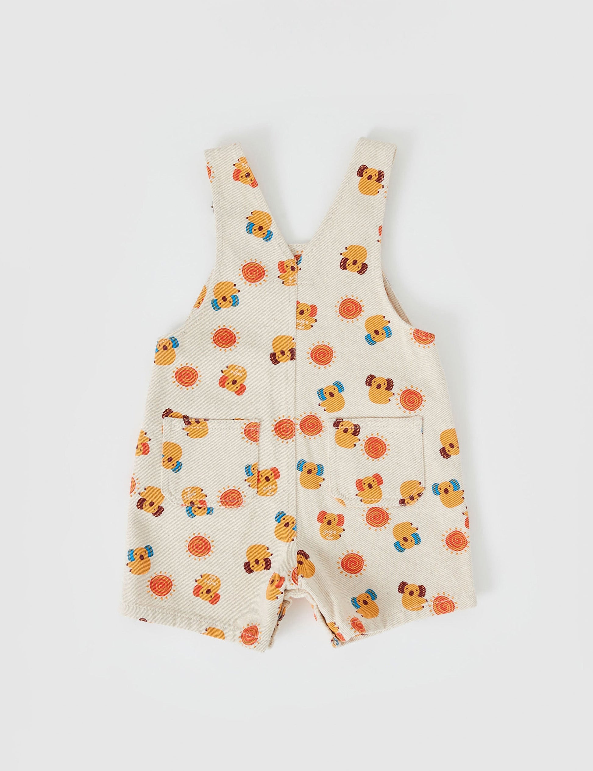 The Goldie + Ace Burton Vintage Washed Denim Koala Overalls in Ivory pictured on a grey background. The material is cotton twill. It is a overall made for babies, toddlers and kids.