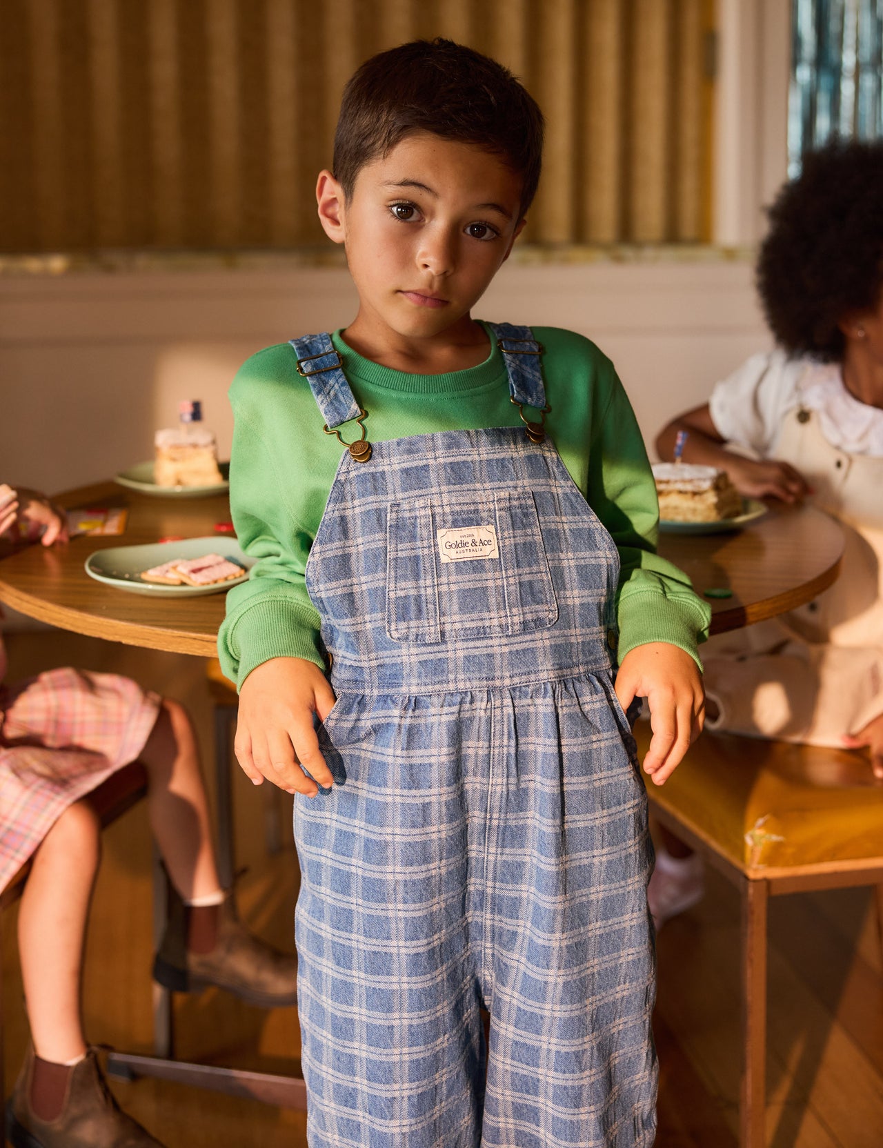 The Goldie + Ace Austin Denim Check Overalls in Blue Denim pictured on a grey background. The material is cotton denim. It is a overall made for babies, toddlers and kids.