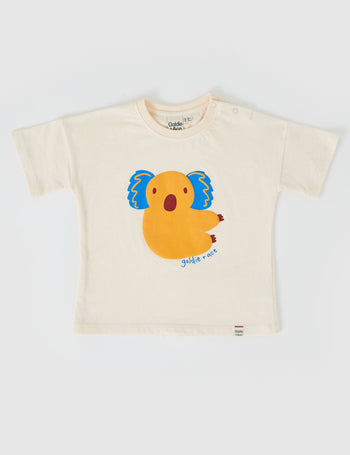 The Goldie + Ace Koala Puff Print T-Shirt in Ivory pictured on a grey background. The material is cotton jersey. It is a top made for babies, toddlers and kids.
